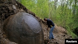 Suad Keserovic cleans a stone ball in Podubravlje village near Zavidovici, Bosnia and Herzegovina, April 11, 2016.