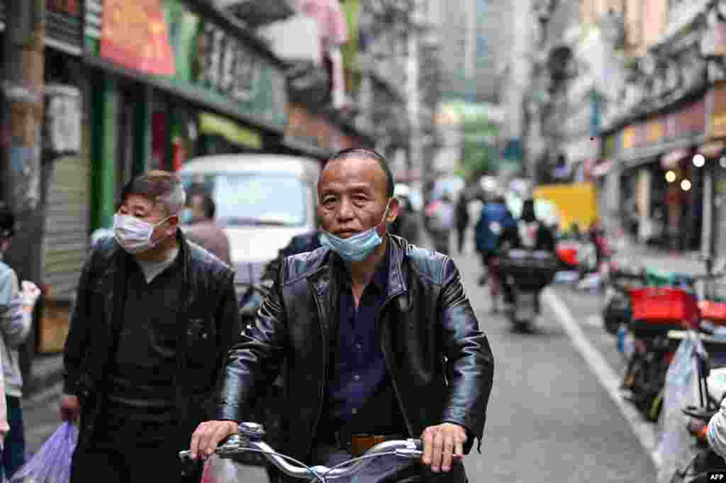 Un hombre que llevaba una máscara facial monta una bicicleta en una calle de Wuhan, en la provincia central china de Hubei, mientras las restricciones de viaje para detener la propagación del coronavirus COVID-19 se levantaron en la ciudad.