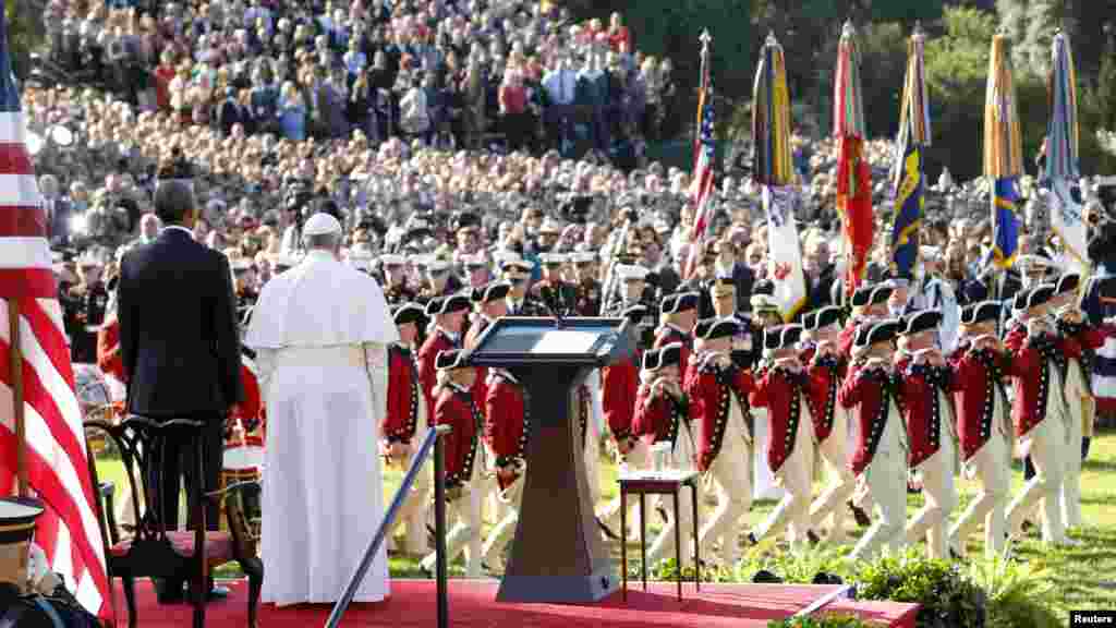 U.S. President Barack Obama and Pope Francis watch onstage as the "Old Guard" fife and drum corps marches past during an official welcome ceremony on the South Lawn of the White House, Sept. 23, 2015.