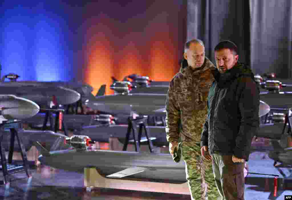 Ukrainian President Volodymyr Zelenskyy, right, and Commander-in-Chief of the Armed Forces of Ukraine Oleksandr Syrsky speak next to the first batch of Ukrainian-made drone missiles &quot;Peklo&quot; (Hell) in Kyiv.