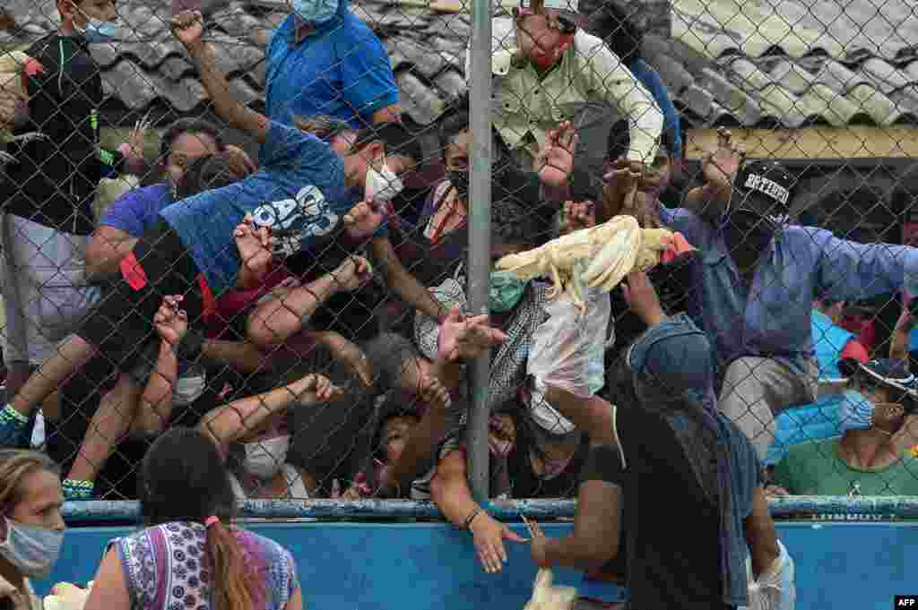 Amid the coronavirus pandemic, people crowd to receive hens being given by Honduran presidential pre-candidate for the LIBRE party, Wilfredo Mendez, in the working-class neighborhood of El Carrizal, in Tegucigalpa.