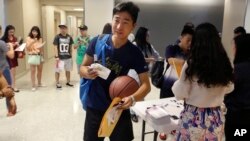 FILE - Weikang Nie, a finance graduate student from China, walks into an orientation for Chinese students at the University of Texas at Dallas in Richardson, Texas, Aug. 22, 2015.
