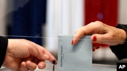 Un électeur vote dans un bureau de vote pour le second tour des élections régionales françaises, le 27 juin 2021 au Touquet, dans le nord de la France.