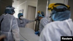 Médicos y enfermeras parados frente a la entrada de la Unidad de Cuidados Intensivos (UCI) para pacientes que padecen la enfermedad por coronavirus (COVID-19) en el hospital El Tunal en Bogotá, Colombia, 12 de junio de 2020.