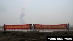 Aksi aktivis Walhi Jawa Timur memperingati 12 Lumpur Lapindo di tanggul lumpur Lapindo, Porong, Sidoarjo, Jawa Timur, 29 Mei 2018. (Foto: VOA/Petrus Riski)