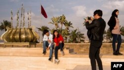 Des touristes asiatiques prennent une photographie devant la tour d'Hassan à Rabat, le 22 février 2017.