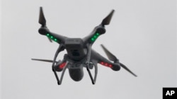 A drone hovers over the scene of an explosion that leveled two apartment buildings in the East Harlem neighborhood of New York, New York, March 12, 2014.