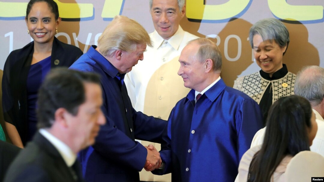 U.S. President Donald Trump and Russian President Vladimir Putin shake hands as they take part in a family photo at the APEC summit in Danang, Vietnam, Nov. 10, 2017.