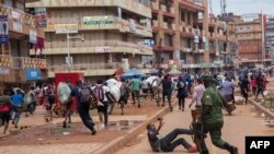 Un officier de police poursuit des vendeurs de rue à Kampala, en Ouganda, le 26 mars 2020. (Photo: Badru KATUMBA / AFP)