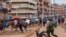 Un officier de police poursuit des vendeurs de rue à Kampala, en Ouganda, le 26 mars 2020. (Photo: Badru KATUMBA / AFP)