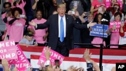 President Donald Trump gestures to supporters as he takes the stage for a campaign rally in Charlotte, North Carolina, Oct. 26, 2018.
