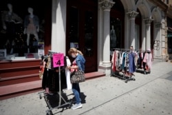 FILE - Shoppers browse racks of clothes at a newly re-opened retail store along Broadway in lower Manhattan on the first day of the phase two re-opening of businesses following the outbreak of the coronavirus disease in New York City, June 22, 2020.