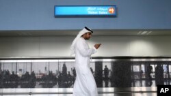 FILE - In this Oct. 27, 2013 file photo, a worker looks at his mobile phone at the Al Maktoum International Airport in Dubai, United Arab Emirates. 