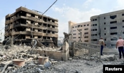 People inspect the damage in the aftermath of Israeli strikes on Beirut's southern suburbs, Oct. 7, 2024.