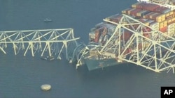 FILE— Parts of the Francis Scott Key Bridge remain after a container ship collided with a support Tuesday, March 26, 2024 in Baltimore. The major bridge in Baltimore snapped and collapsed after a container ship rammed into it early Tuesday.