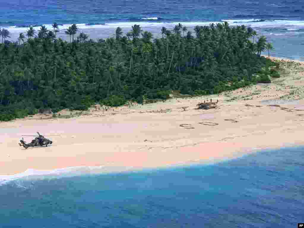 In this photo provided by the Australian Defense Force, an Australian Army helicopter lands on Pikelot Island in the Federated States of Micronesia, where three men were found, Aug. 2, 2020, safe and healthy after missing for three days.