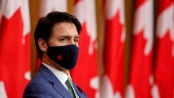 FILE PHOTO: Canadian Prime Minister Justin Trudeau listens while wearing a mask at a news conference in Ottawa