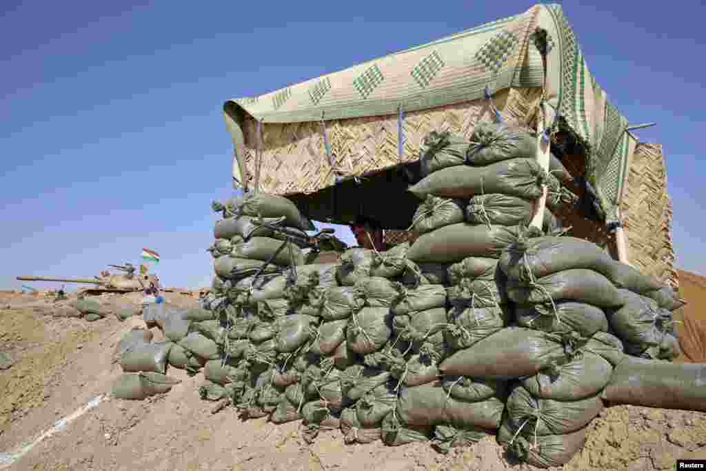 A Kurdish peshmerga fighter takes up position against the Islamic State on the Khazir frontline leading to Mosul, Iraq.