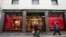 FILE - People walk in front of Gucci shop in Monte Napoleone street in Milan, Italy, Oct. 20, 2016. Nigerian women who were trafficked to Italy to work as prostitutes have found new work in a handbag and dressmaking shop that recently received fabric leftovers from Gucci.