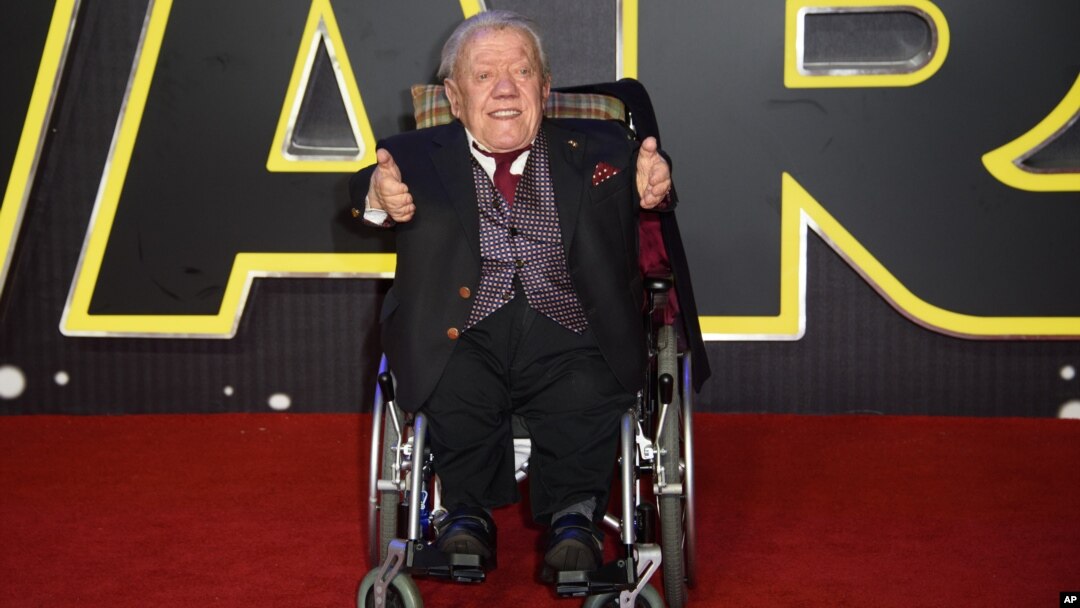FILE - Britain Star Wars The Force Awakens Premiere: Kenny Baker poses for photographers upon arrival at the European premiere of the film 'Star Wars: The Force Awakens ' in London, Wednesday, Dec. 16, 2015.