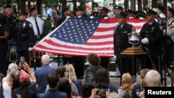 Ceremonia para conmemorar el 22º aniversario de los ataques del 11 de septiembre de 2001 al World Trade Center. Una bandera estadounidense es sostenida durante el acto solemne en el Museo y Memorial Nacional en la ciudad de Nueva York, EEUU, 11 de septiembre de 2023.