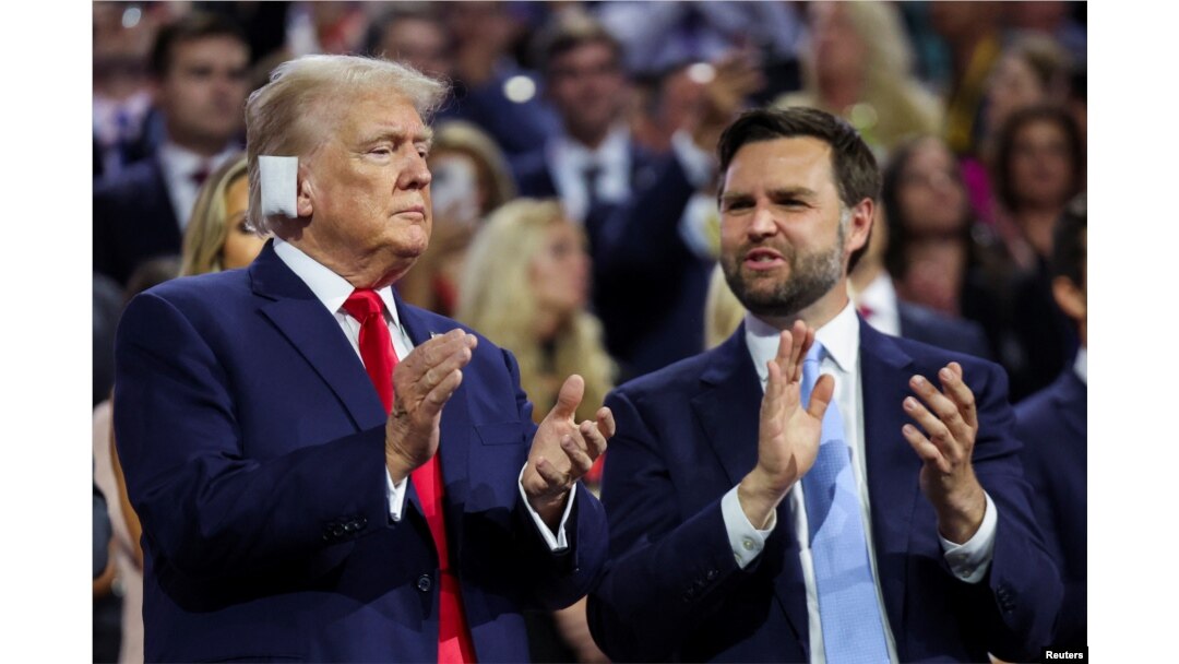 Republican presidential nominee and former U.S. President Donald Trump applauds with his choice for vice president, J.D. Vance, at the Republican National Convention at the Fiserv Forum in Milwaukee, July 15, 2024.