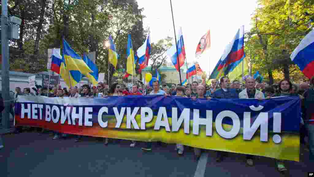 People carry a banner reading "no war with Ukraine" during an anti-war rally in downtown Moscow, Russia, Sept. 21, 2014. 