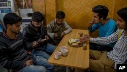 Para pelajar Kashmir belajar dengan menggunakan internet dari telepon genggam mereka di sebuah restoran di Srinagar, daerah Kashmir yang dikontrol oleh India, 26 April 2017. (AP Photo/Dar Yasin) 