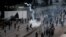 Pakistani protesters hurl back tear gas fired by police, unseen, to stop them from walking toward the U.S. consulate during a demonstration in Karachi, Pakistan, Sunday, Sept. 16, 2012.