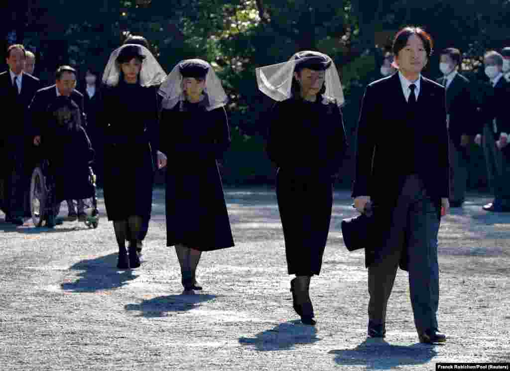 Japan&#39;s Crown Prince Akishino and Crown Princess Kiko walk, followed by Princess Aiko and Princess Kako, to attend a funeral service for Princess Mikasa at Toshimagaoka cemetery in Tokyo.