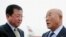 日本首相顾问饭岛勋(右)2013年5月14日抵达朝鲜平壤机场，朝鲜外务省亚洲事务部副主任金哲镐(左)在机场迎接。
