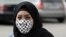 Une femme porte un masque avec les motifs du Kaffiyeh, symbole de la lutte des Palestiniens, dans le camp de réfugiés de Burj el-Barajneh, au sud de Beyrouth au Liban le 27 mars 2020.