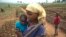 FILE - A woman and her child, who fled from rebel attacks, stand in a field, in Tshikapa, Kasai region, Democratic Republic of Congo, July 27, 2017.