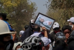 Un hombre sostiene una foto de Kyal Sin durante su entierro en Mandalay, Myanmar, el jueves 4 de marzo de 2021. Kyal Sin recibió un disparo en la cabeza por las fuerzas de seguridad de Myanmar durante una manifestación contra el golpe, en la víspera.