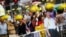 People take pictures behind a cutout of Chinese President Xi Jinping on which pro-democracy protesters put goggles and a yellow ribbon, their symbols, in the part of Mongkok shopping district protesters are occupying in Hong Kong, Oct. 31, 2014.