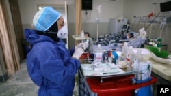 In this Tuesday, June 16, 2020, photo, a nurse prepares medicines for COVID-19 patients at the Shohadaye Tajrish Hospital in Tehran, Iran. After months of fighting the coronavirus, Iran only just saw its highest single-day spike in reported cases…