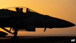 FILE - A fighter jet maneuvers on the deck of the USS Dwight D. Eisenhower in the Red Sea, June 11, 2024. 