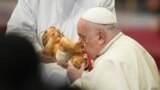 Pope Francis kisses the baby Jesus as he presides over an Epiphany mass in St.Peter's Basilica, at the Vatican, Monday, Jan. 6, 2025. 