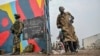 Government soldiers and police officers, at right, who surrendered to M23 rebels, left, board trucks to an undisclosed location in Goma, Democratic Republic of Congo, on Jan. 30, 2025.