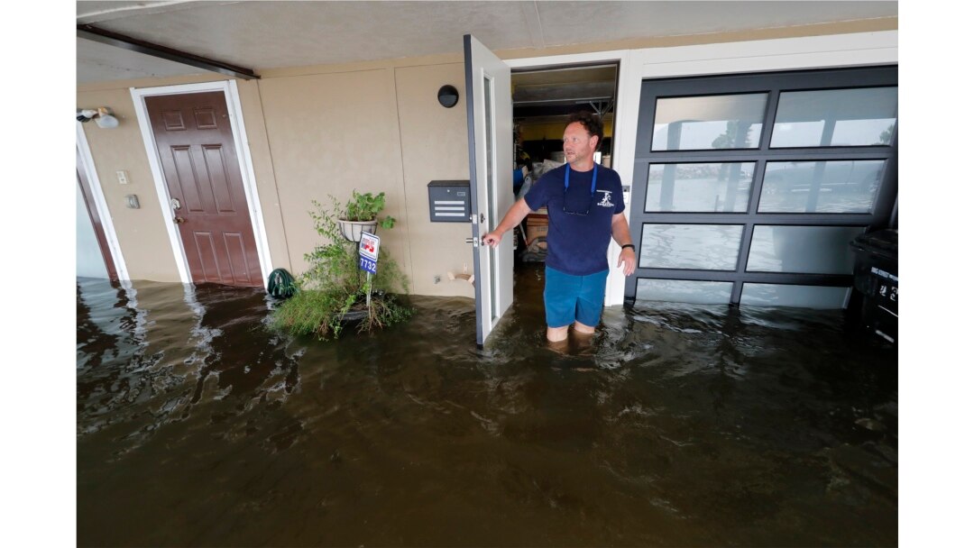 Rudy Horvath walks out of his home, a boathouse in the West End section of New Orleans, as it takes on water a from storm surge in Lake Pontchartrain in advance of Tropical Storm Cristobal, June 7, 2020.
