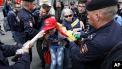 Russian police officers detain a gay rights activist during an opposition rally for free internet in Moscow, Russia, Aug. 26, 2017. 