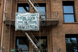 A banner against the presence of federal law enforcement officers is pictured on a fire escape in downtown Portland, Oregon, July 17, 2020.