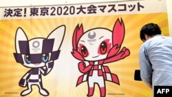 Seorang awak kamera TV sedang merekam desain yang memenangkan kompetisi maskot resmi Olimpiade dan Paralimpiade Tokyo 2020, di sebuah sekolah dasar di Tokyo, 28 Februari 2018.