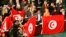 Members of the Tunisian parliament wave flags after approving the country's new constitution in the assembly building in Tunis, Jan. 26, 2014.