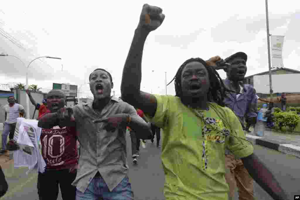 Kungiyar kwadago ta TUC da &#39;ya&#39;yan kungiyoyin al&#39;umma a Lagos suna zanga-zanga a daidai lokacin da suke wuce wani gidan mai dake dauke da sabon farashin man, a Lagos, Najeriya, Laraba 18 Mayu, 2016.