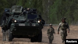 U.S. Army soldiers walk in formation during the Sword 26 exercise, approaching a MEDEVAC vehicle as NATO forces demonstrate innovation in battlefield casualty evacuation using drones and medical tech in Bemowo Piskie, Poland, May 11, 2026.