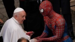 Pope Francis meets Spider-Man, who presents him with his mask, at the end of his weekly general audience with a limited number of faithful in the San Damaso Courtyard at the Vatican, Wednesday, June 23, 2021. (AP Photo/Andrew Medichini)