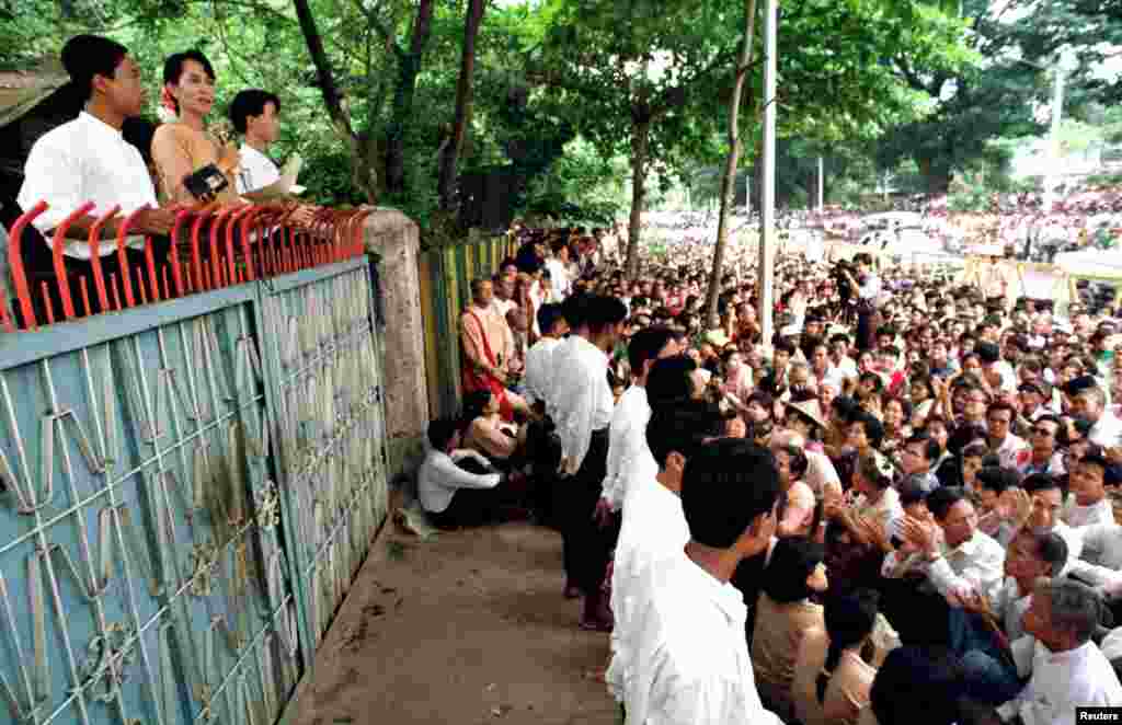 Aung San Suu Kyi addresses about 4,000 people gathered outside her house in Rangoon, Burma, June 1, 1996.