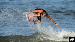 Australia's Owen Wright goes airborne as he rides a wave during a training session at the 2020 Summer Olympics, Thursday, July 22, 2021, at Tsurigasaki beach in Ichinomiya, Japan.