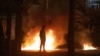 Dečak posmatra dok se plamen i dim dižu iza njega na mestu nasilja Njutanabiju, severno od Belfastga, u Severnoj Irskoj, 3. aprila 2021.